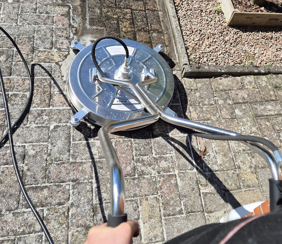 Medewerker van V.J. Buitenreiniging aan het werk met een professionele oppervlaktereiniger